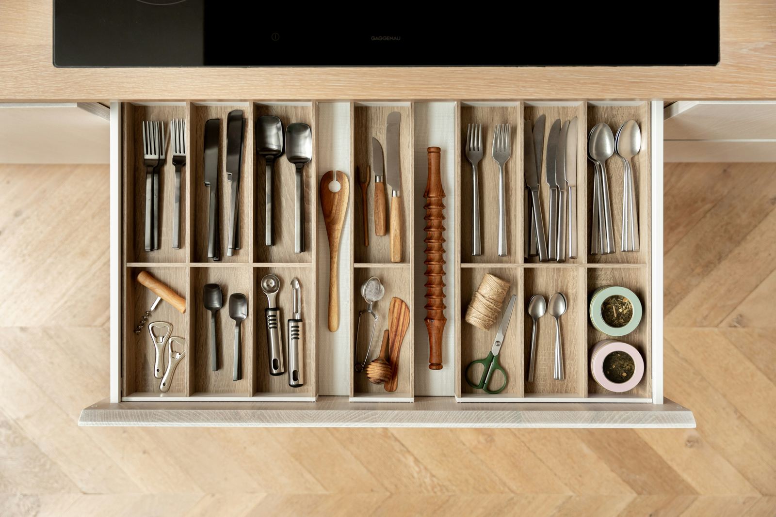 Overhead view of a neatly organized kitchen drawer with sorted utensils